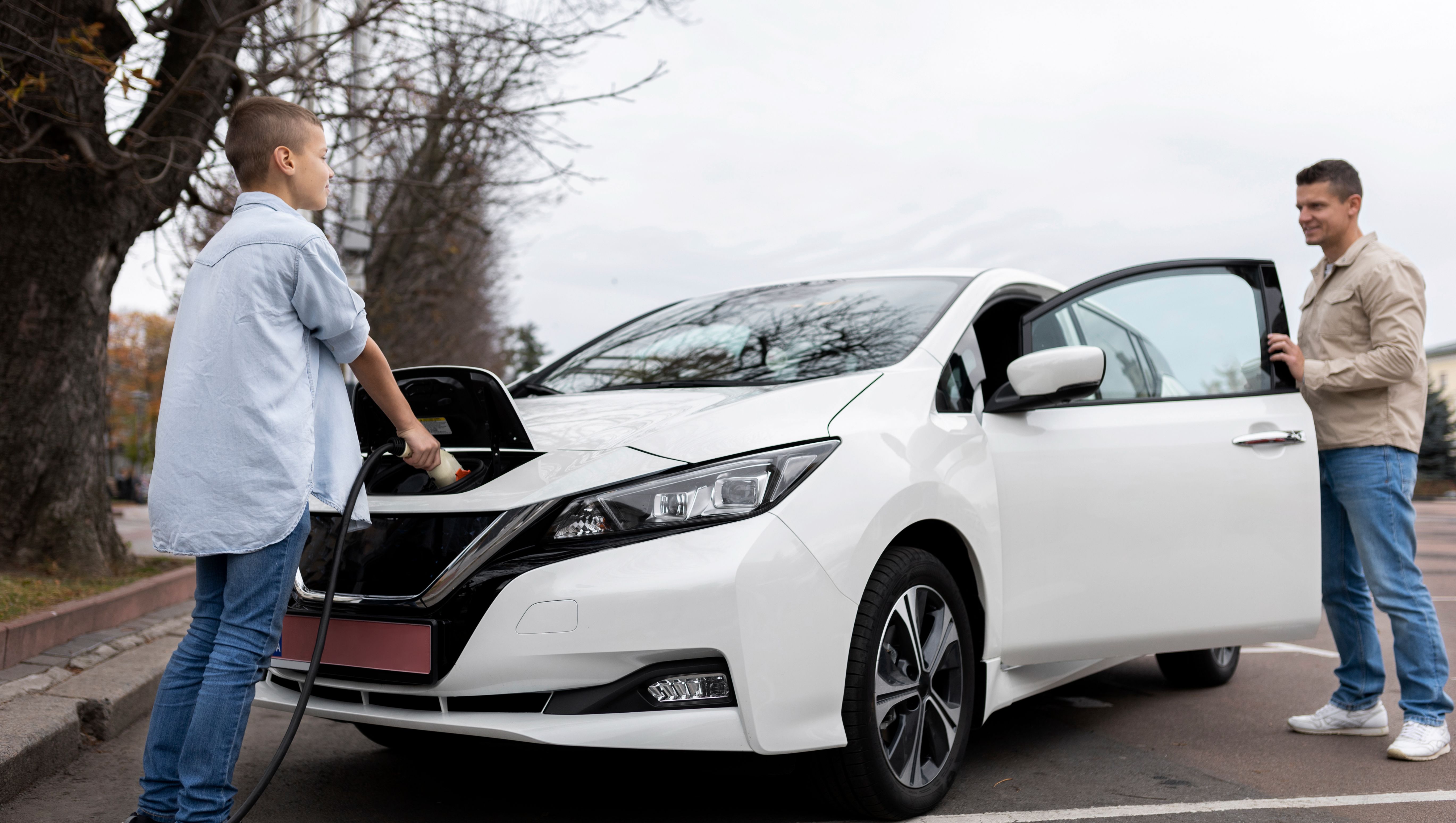 pojke laddar en vit elbil